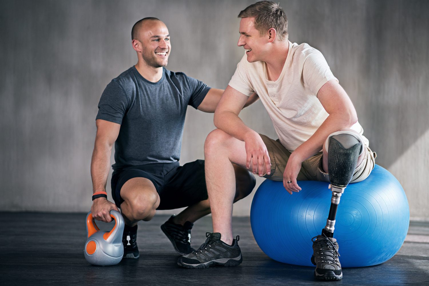 Trainer and adaptive athlete discussing fitness goals in the gym